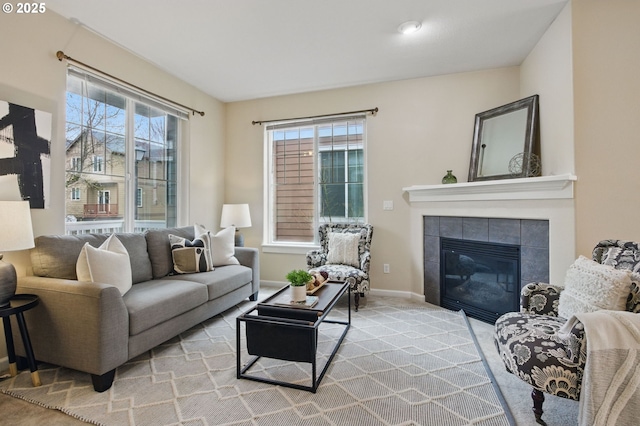 living area with carpet flooring, baseboards, and a tile fireplace