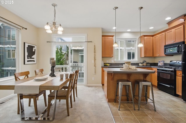 kitchen with visible vents, black appliances, a breakfast bar, a center island, and recessed lighting