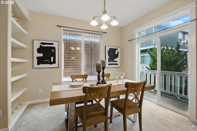 dining area featuring visible vents, light colored carpet, an inviting chandelier, and baseboards