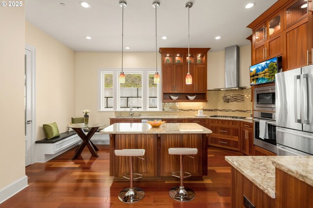 4018 NW Riggs Dr, Portland, OR 97229 - kitchen featuring a sink, wall chimney range hood, appliances with stainless steel finishes, brown cabinetry, and backsplash