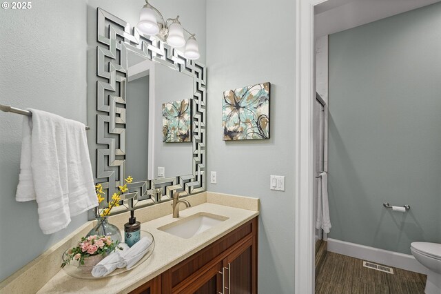 4018 NW Riggs Dr, Portland, OR 97229 - full bath featuring vanity, visible vents, toilet, a shower, and wood finished floors