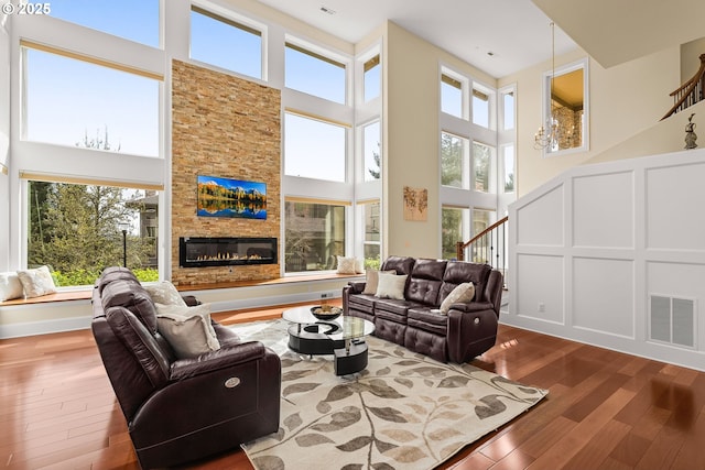 4018 NW Riggs Dr, Portland, OR 97229 - living area featuring visible vents, hardwood / wood-style floors, a towering ceiling, and a healthy amount of sunlight