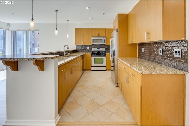 8522 N Central St Unit 17-1, Portland, OR 97203 - kitchen featuring stainless steel appliances, a sink, a peninsula, tasteful backsplash, and light stone countertops