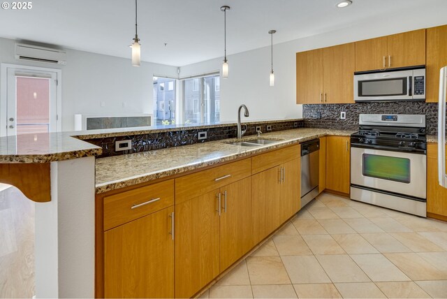 8522 N Central St Unit 17-1, Portland, OR 97203 - kitchen featuring stainless steel appliances, a wall unit AC, a sink, tasteful backsplash, and stone countertops
