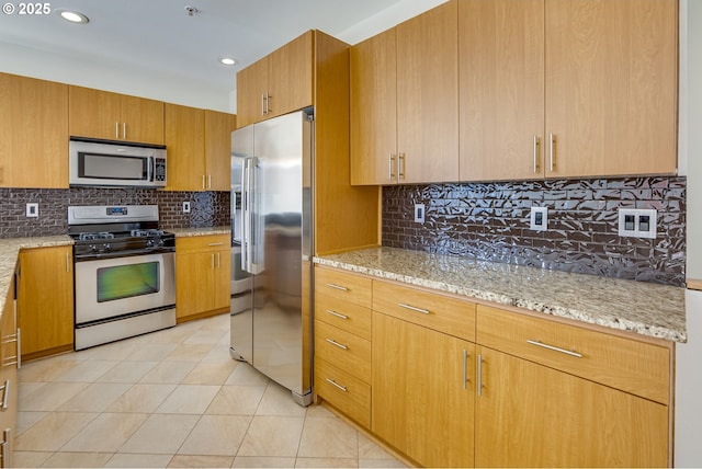8522 N Central St Unit 17-1, Portland, OR 97203 - kitchen featuring appliances with stainless steel finishes, decorative backsplash, light stone countertops, light tile patterned floors, and recessed lighting