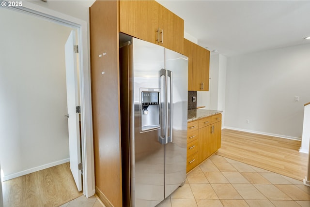 8522 N Central St Unit 17-1, Portland, OR 97203 - kitchen featuring stainless steel fridge, light stone counters, light wood finished floors, and baseboards