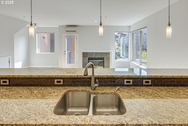 8522 N Central St Unit 17-1, Portland, OR 97203 - kitchen featuring a sink, a wall unit AC, open floor plan, light stone countertops, and a tiled fireplace
