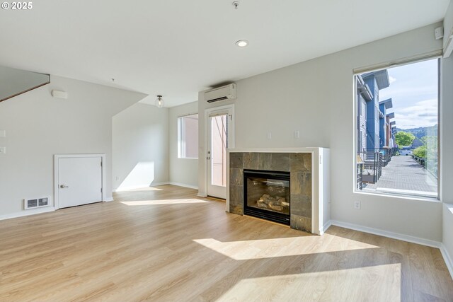 8522 N Central St Unit 17-1, Portland, OR 97203 - unfurnished living room featuring an AC wall unit, light wood-style floors, a fireplace, baseboards, and recessed lighting