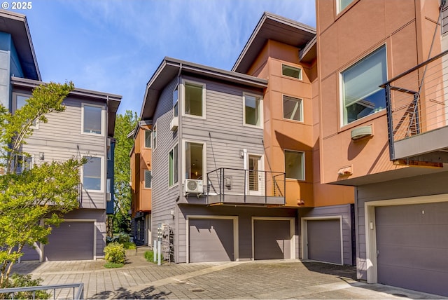 8522 N Central St Unit 17-1, Portland, OR 97203 - back of property with an attached garage, a wall unit AC, driveway, and a balcony