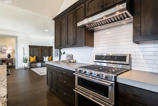 kitchen featuring dark hardwood / wood-style flooring, wall chimney range hood, decorative backsplash, and range with two ovens