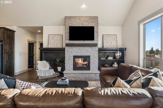 living room featuring vaulted ceiling, dark wood-type flooring, and a fireplace