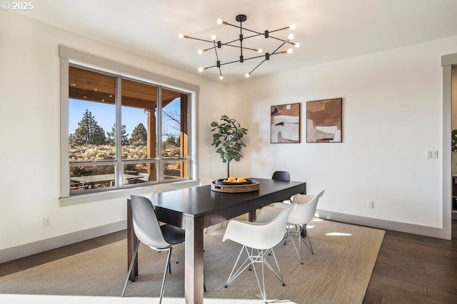 dining room with dark wood-type flooring and a chandelier