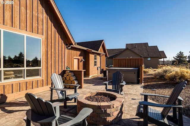 view of patio with a hot tub and a fire pit