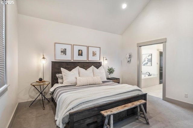 bedroom featuring ensuite bathroom, high vaulted ceiling, and carpet