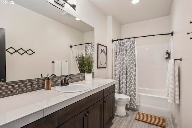 full bathroom featuring vanity, tasteful backsplash, wood-type flooring, shower / bath combination with curtain, and toilet