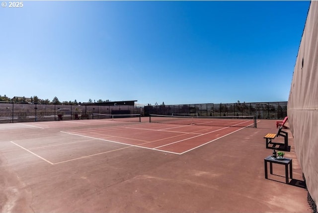 view of tennis court featuring basketball hoop