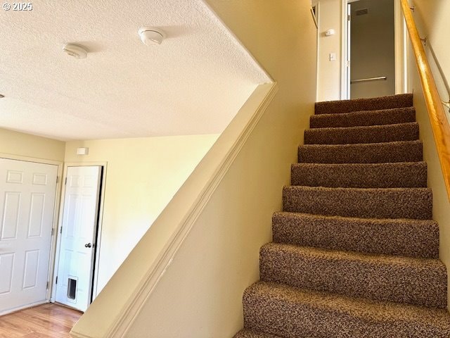 stairway with hardwood / wood-style floors