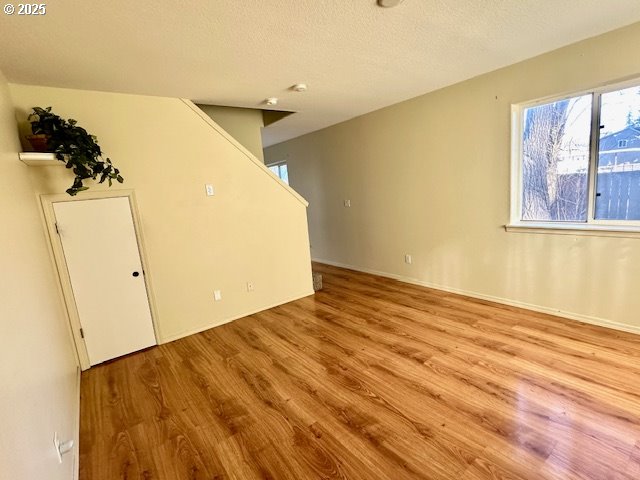 empty room featuring a textured ceiling and light wood-type flooring