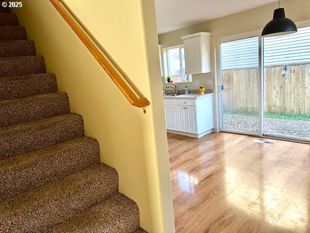 stairway with sink and hardwood / wood-style floors