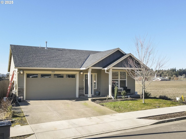 view of front of house featuring a garage, a front yard, and covered porch