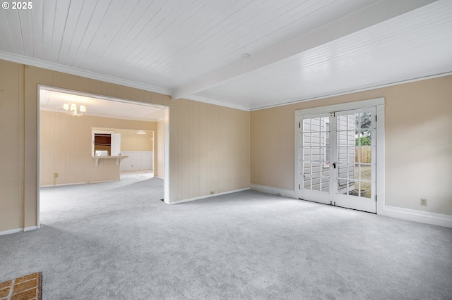 empty room with light carpet, ornamental molding, beamed ceiling, and an inviting chandelier