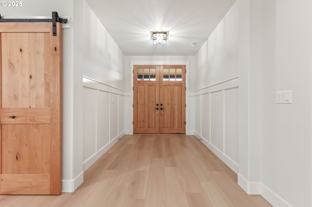 648 Parker Loop, Silverton, OR 97381 - entryway with light wood-type flooring, a decorative wall, and a barn door