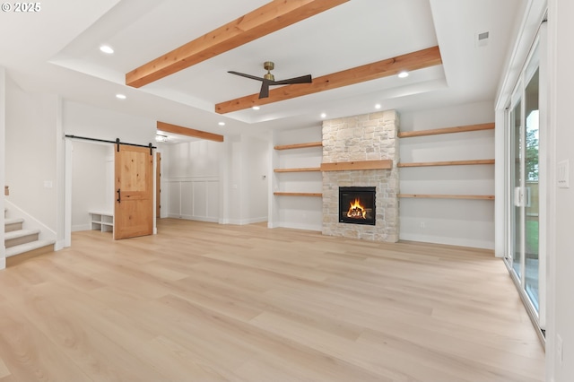 648 Parker Loop, Silverton, OR 97381 - unfurnished living room with a barn door, recessed lighting, beam ceiling, light wood-style floors, and a fireplace