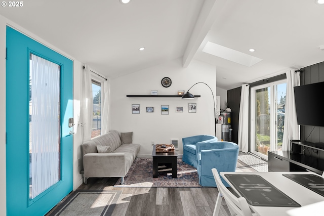 living room with water heater, dark hardwood / wood-style floors, and vaulted ceiling with skylight