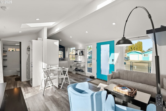 living room with wood-type flooring and vaulted ceiling with skylight