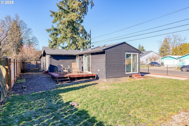 back of house featuring a deck and a lawn