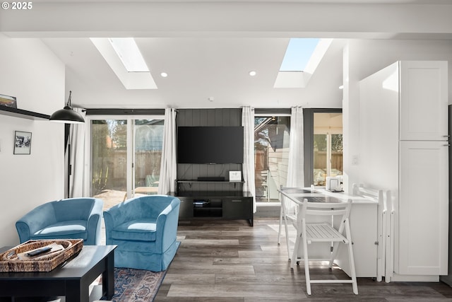 living room featuring wood-type flooring and vaulted ceiling with skylight