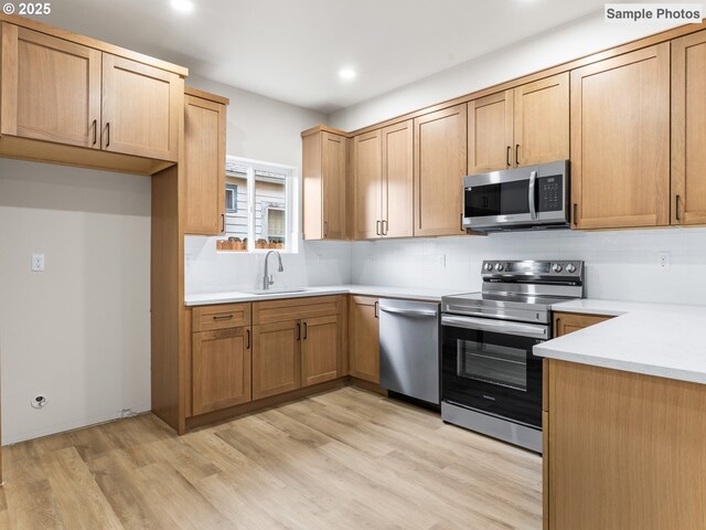 5866 N Missouri Ave Unit 4, Portland, OR 97206 - kitchen with stainless steel appliances, a sink, recessed lighting, light wood finished floors, and light countertops