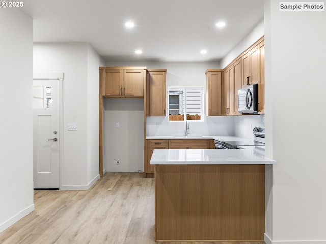 5866 N Missouri Ave Unit 4, Portland, OR 97206 - kitchen featuring electric range oven, light wood-type flooring, a peninsula, light countertops, and recessed lighting