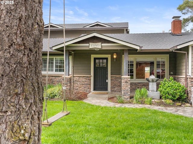 13145 SW 61st Ave, Portland, OR 97219 - view of front of property with stone siding, a front lawn, a chimney, and roof with shingles