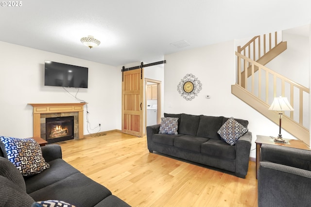 403 W Oxford St, Newberg, OR 97132 - living room featuring wood finished floors, a barn door, stairs, a fireplace, and washer / dryer