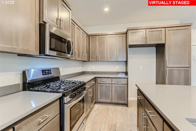 kitchen featuring appliances with stainless steel finishes, recessed lighting, light countertops, and light wood-style floors