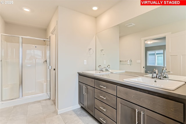 bathroom with double vanity, a stall shower, a sink, and recessed lighting