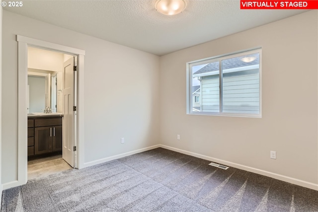 unfurnished bedroom with carpet flooring, visible vents, and baseboards