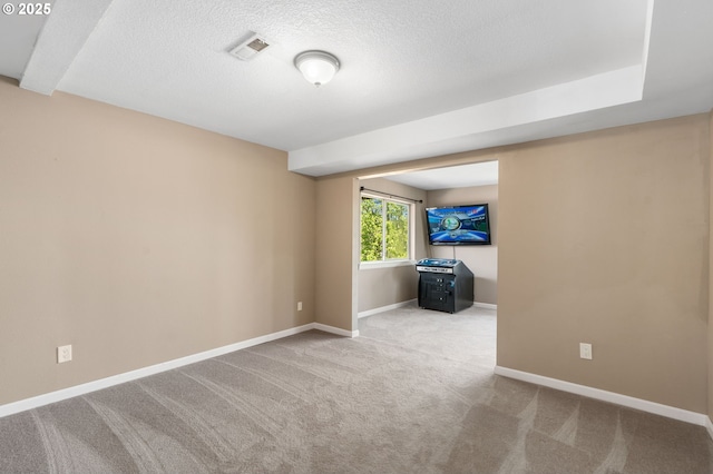 carpeted spare room with baseboards and a textured ceiling