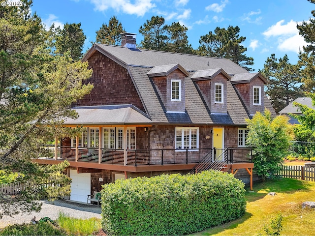 652 Nita Ave, Gearhart, OR 97138 - shingle-style home featuring stone siding, an attached garage, a deck, roof with shingles, and driveway