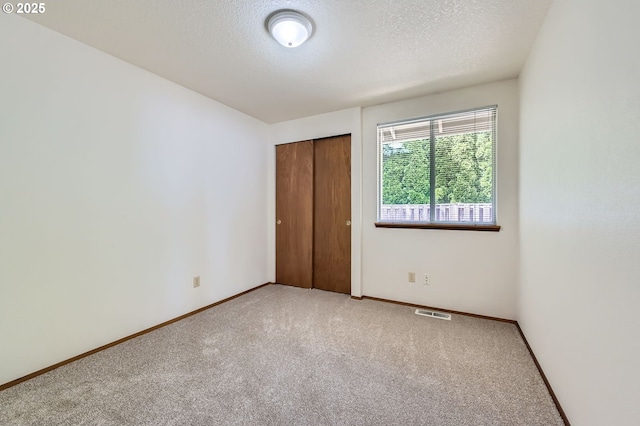 21122 NW Cannes Dr, Portland, OR 97229 - unfurnished bedroom featuring carpet, a textured ceiling, and a closet