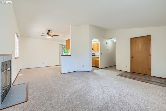 21122 NW Cannes Dr, Portland, OR 97229 - unfurnished living room with a ceiling fan, light carpet, arched walkways, and lofted ceiling
