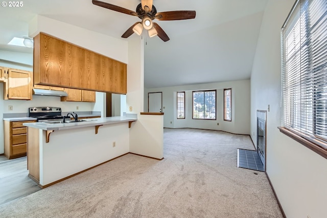 21122 NW Cannes Dr, Portland, OR 97229 - kitchen featuring stainless steel range with electric stovetop, light colored carpet, light countertops, high vaulted ceiling, and a breakfast bar