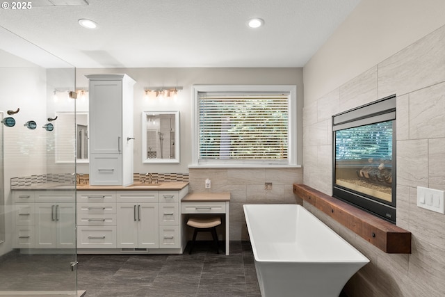 15110 Oyer Dr, Oregon City, OR 97045 - full bathroom with tile walls, vanity, a freestanding tub, a stall shower, and recessed lighting