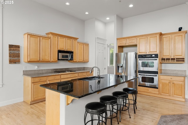 15110 Oyer Dr, Oregon City, OR 97045 - kitchen with appliances with stainless steel finishes, light brown cabinets, light wood-style floors, a breakfast bar area, and recessed lighting