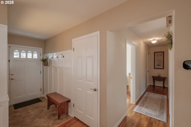 mudroom with light wood finished floors and baseboards