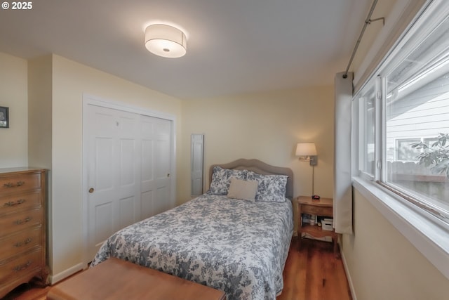 bedroom featuring a closet, baseboards, and wood finished floors