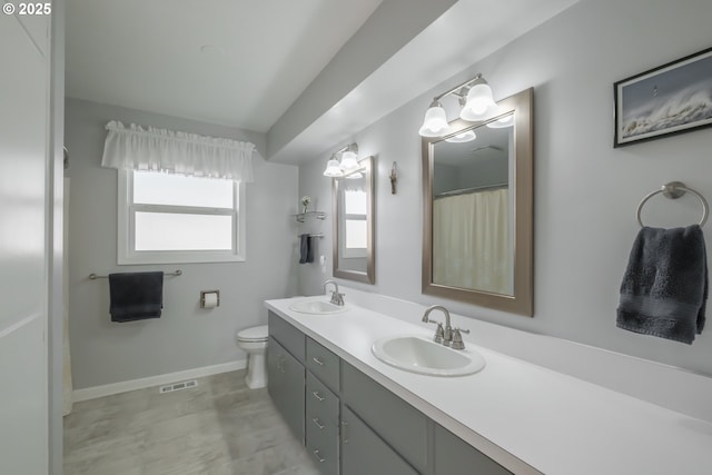 full bath with double vanity, baseboards, visible vents, and a sink