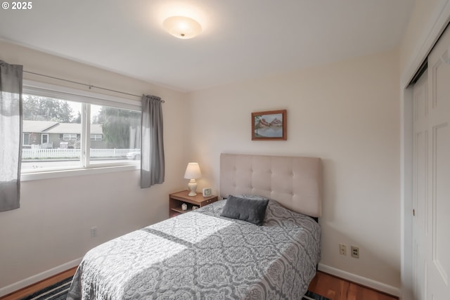 bedroom with baseboards, a closet, and wood finished floors