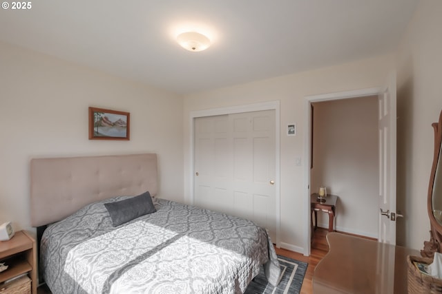 bedroom with a closet, baseboards, and wood finished floors